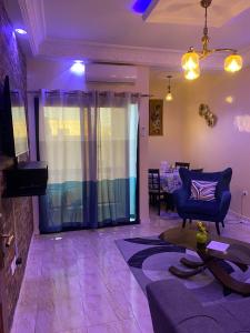 达喀尔Residence Adja Binta Kane Sour的客厅配有紫色照明、沙发和桌子