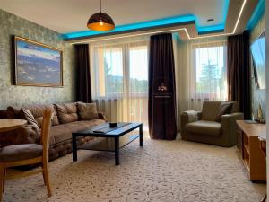 潘波洛沃Deluxe Apartment 33 Mountain Lodge Pamporovo的客厅配有沙发和桌子