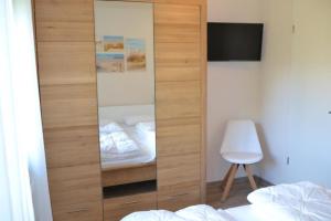 马林费尔德U17 EG - komfortable Ferienwohnung mit Terrasse, Wlan und Kamin的卧室内带镜子的大型木制橱柜