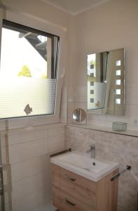 马林费尔德U17 EG - komfortable Ferienwohnung mit Terrasse, Wlan und Kamin的一间带水槽和镜子的浴室以及窗户。