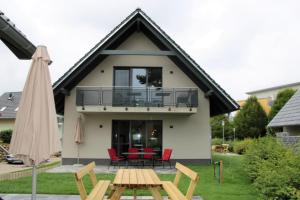 马林费尔德U16 OG - Komfortable Ferienwohnung mit Kamin, Wlan und Seeblick的带阳台和桌椅的房子
