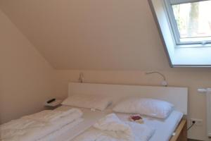 马林费尔德U16 OG - Komfortable Ferienwohnung mit Kamin, Wlan und Seeblick的窗户客房内的一张白色床