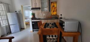 马翁Maun Luxury Oasis的厨房配有带微波炉和冰箱的桌子