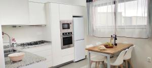 蓬他达维托亚Casa Panorama Sol的厨房配有白色橱柜和一张带椅子的木桌