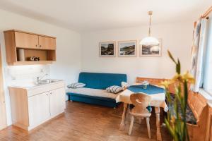 滨湖伦茨Biohof Teufel的厨房配有桌子和蓝色沙发