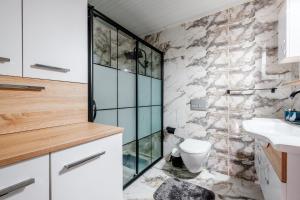 马赫姆拉Modern Flat 5 min to Mahmutlar Beach in Alanya的一间带玻璃淋浴和卫生间的浴室