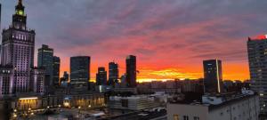 华沙ComeWa Apartments的日落时分享有城市天际线的景致