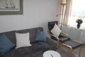 斯洪保因霍泰Ferienwohnung L412 für 2-4 Personen an der Ostsee的客厅配有沙发和椅子
