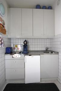 斯洪保因霍泰Ferienwohnung L412 für 2-4 Personen an der Ostsee的厨房配有白色橱柜和水槽