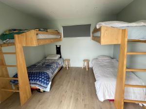 Karikari PeninsulaWhatuwhiwhi Views的客房设有两张双层床和一张床。
