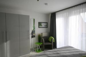 达默Lange Wiese 8/101的卧室配有床、椅子和窗户。