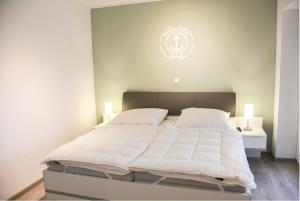 达默Zur Strandwiese W3的一间卧室配有一张带两盏灯的大型白色床。