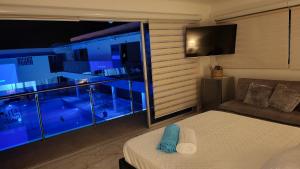 吉拉尔多特PISCINA SARITA CLUB BOUTIQUE的客房设有一张床和带电视的窗户。