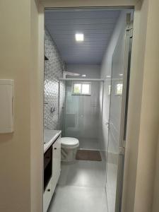 伊瓜苏Aconchego, no melhor lugar de Foz!的一间带卫生间和玻璃淋浴间的浴室