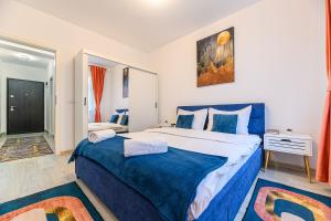 布拉索夫Grandis Residence Apartment的一间卧室配有一张带蓝色毯子的大床