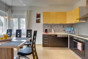 普拉Villa Marcelia的厨房配有黄色橱柜和桌椅