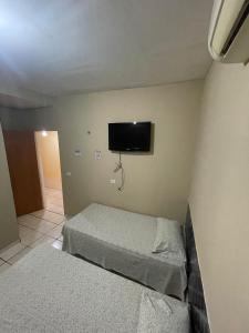 特雷西纳Hotel Horizonte的一间卧室配有两张床和一台平面电视