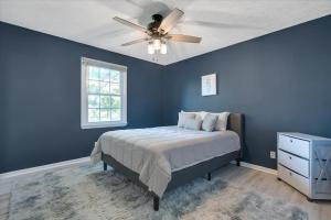 法兰克福The Kentucky Bluegrass Retreat的蓝色卧室配有床和吊扇