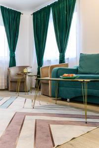 布拉索夫Grandis Residence Apartment的客厅配有绿色沙发和2张桌子