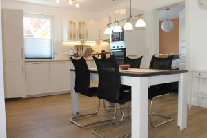博恩Ferienwohnung de Windroos的厨房配有桌子和黑色椅子