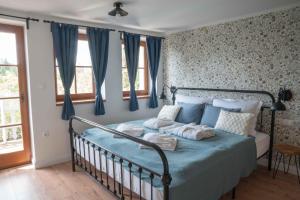 埃格尔EgerCottages - Bikavér Cottage的一间卧室配有蓝色的床和蓝色窗帘