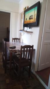 因贝Apto Central Barra de Imbé的餐桌、椅子和墙上的电视