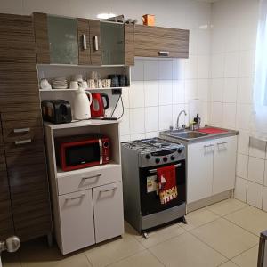 伊基克Casa dos dormitorios的一间带炉灶和微波炉的小厨房