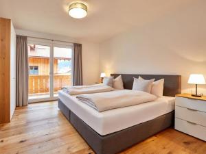 加尔米施-帕滕基兴Fewo Sterntaler OG in Garmisch-Partenkirchen的一间卧室配有一张带白色床单的大床