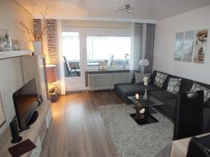 库克斯港Watten-Blick 1的客厅配有黑色沙发和电视