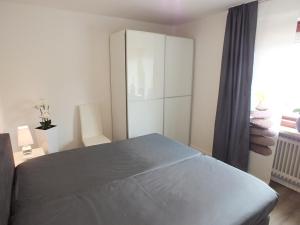 库克斯港Watten-Blick 2的一间卧室配有床和白色橱柜