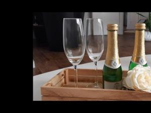瓦尔斯罗德NEU Ferienwohnung Walsrode的桌子上木托盘里放两杯香槟酒