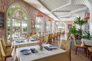 非斯菲斯尼甘宫万豪酒店&度假村的餐厅设有白色的桌椅和窗户。