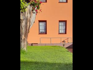 吕本瑙Zur alten Gurkeneinlegerei的一座橙色的建筑,设有窗户和绿色庭院