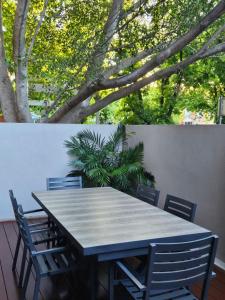 阿德莱德North Adelaide Apartment的树木繁茂的庭院里设有桌椅