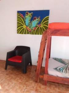 希门尼斯港OSA SURF HOSTAL的一间房间,配有椅子和墙上的绘画作品