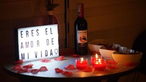 吉拉尔多特PISCINA SARITA CLUB BOUTIQUE的一张带蜡烛的桌子和一瓶葡萄酒