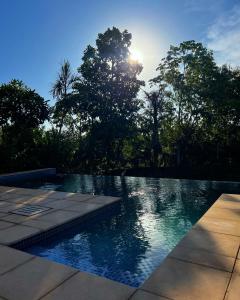 ItauguáGranja Relax的游泳池背面有太阳