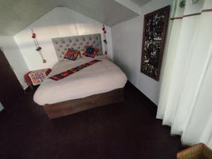 普诺TITICACA WORLDWIDE LODGE的小卧室配有带白色床单和枕头的床