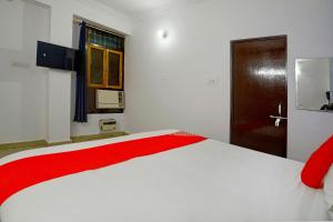 勒克瑙OYO Flagship Hotel Drip Inn的卧室配有一张大白色床和红色毯子