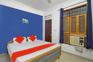 HasanganjOYO Flagship Hotel Drip Inn的一间卧室配有一张蓝色墙壁的床和一扇窗户