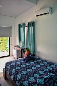 别霍港Ocean's Breeze Apartment and Rooms的一间卧室配有一张床、一个梳妆台和一扇窗户。