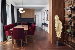 兹拉蒂博尔21st Century Zlatibor Residence, Spa & Wellness by Adora的一间带桌子和红色椅子的用餐室