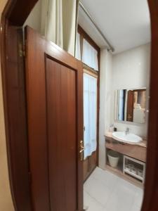 奥维多Uría 25 rooms的一间带木门和水槽的浴室