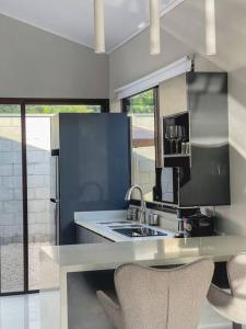 卡里略Fortu House的厨房配有水槽和带椅子的柜台。
