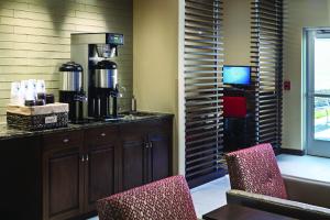 苏福尔斯艾洛斯泰酒店的咖啡吧,配有两把椅子和咖啡壶