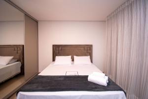 戈亚尼亚Charmosos Flats no Setor Bueno TXP的一间卧室配有带白色床单和枕头的床。