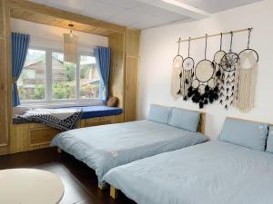 大叻Belle House Đà Lạt的一间卧室设有两张床和窗户。