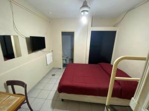 布宜诺斯艾利斯迈特套房旅馆的小房间设有红色的床和一张桌子