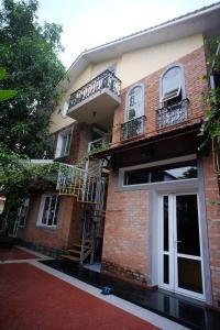 顺化Lagom Home的一座砖砌建筑,设有楼梯和阳台