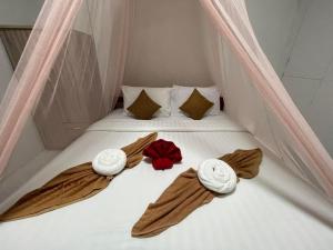 俊穆岛Happy Home Kohjum的帐篷内的一张床位,上面有毛巾和鲜花